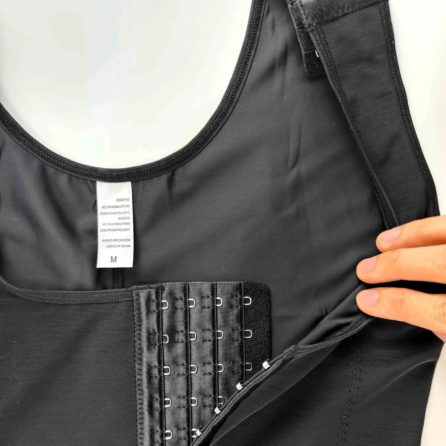 a person is holding a black piece of Butt Lifter Postpartum Girdle BBL Underbust Bodysuit