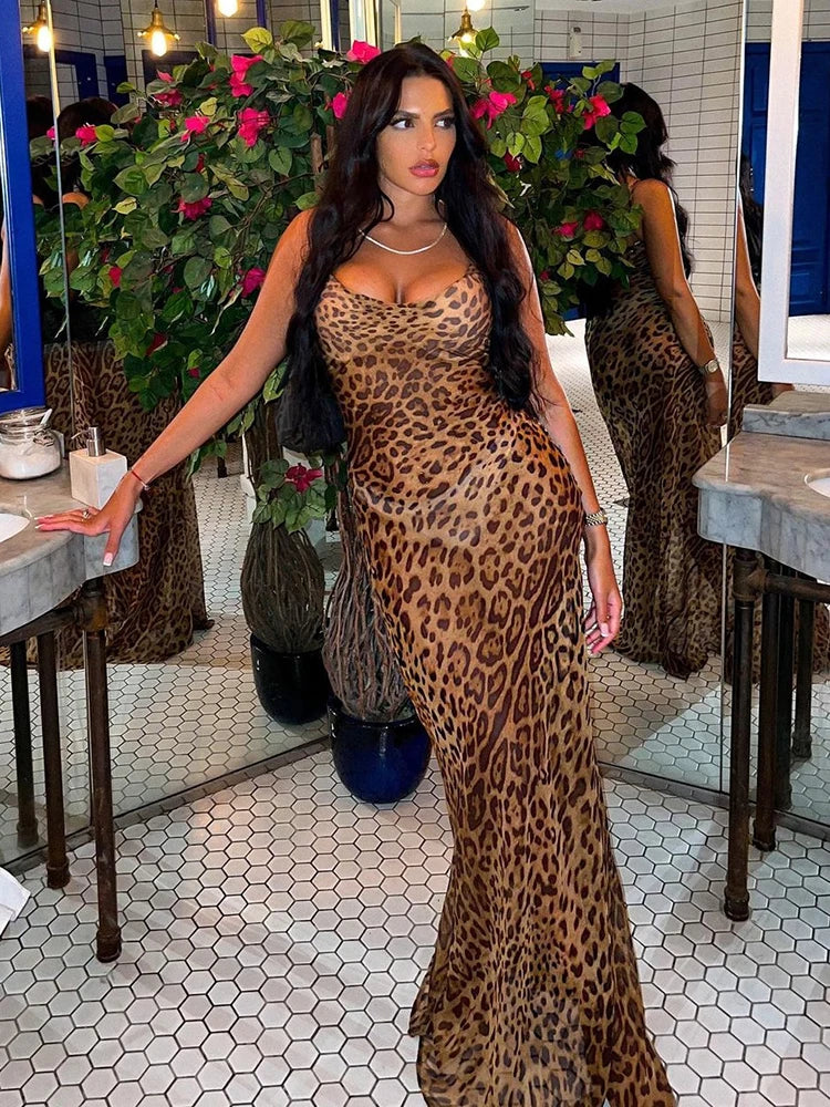 a woman in a leopard print dress standing in front of a mirror